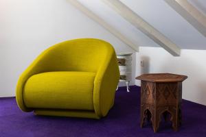 a yellow chair in a room with a table at Apartments and Rooms Lejletul in Dubrovnik +20 photos