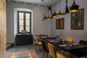 a dining room with tables and chairs and a desk at Apartments and Rooms Lejletul in Dubrovnik