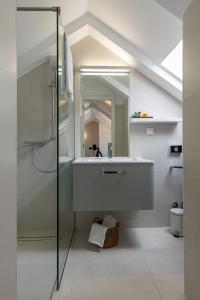 a bathroom with a sink and a shower with a mirror at Apartments and Rooms Lejletul in Dubrovnik