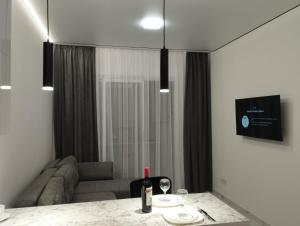 a living room with a table with a bottle of wine at Елітна квартира-студія . in Ternopil