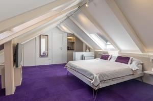 a bedroom with a large bed with purple carpet at Apartments and Rooms Lejletul in Dubrovnik