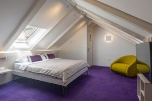 a bedroom with a bed and a yellow chair at Apartments and Rooms Lejletul in Dubrovnik