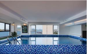 a large swimming pool with blue tiles on the floor at Sea Pearl Hotel in Nha Trang