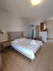 ein Schlafzimmer mit einem großen weißen Bett in einem Zimmer in der Unterkunft Studios Giota in Sarti