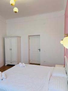 a bedroom with a large white bed with two towels at Sí Apartments Aquapark in Oradea