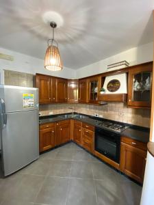 a kitchen with wooden cabinets and a stainless steel refrigerator at Case vacanze Azzurra in Marina di Camerota