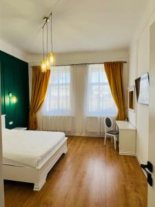 a bedroom with a bed and a desk and window at Sí Apartments Aquapark in Oradea