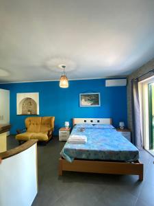 um quarto azul com uma cama e um sofá em Case vacanze Azzurra em Marina di Camerota