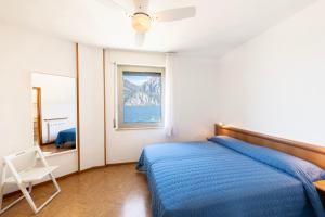 Un dormitorio con una cama azul y una ventana en Residence Casa al Sole Apartments, en Nago-Torbole