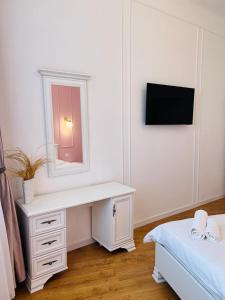 a bedroom with a white desk and a mirror at Sí Apartments Aquapark in Oradea