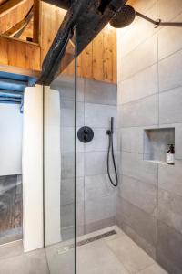 una doccia con porta in vetro in bagno di Het Kostershuisje a Nuenen