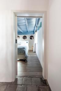Het Kostershuisje في نوينين: ممر يؤدي إلى غرفة نوم مع سرير