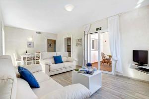 a living room with a white couch and a tv at Villa Ginevra in Son Bou