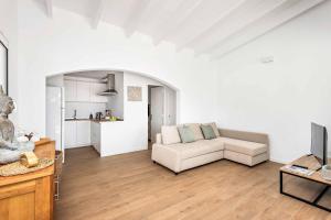 uma sala de estar branca com um sofá e uma cozinha em Villa Belvedere em Cala'n Porter