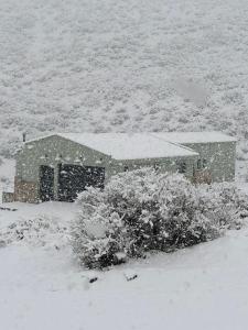 una casa cubierta de nieve en medio de un campo en Piri Home Casa de Montaña en Los Molles