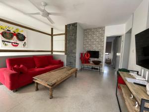 a living room with a red couch and a table at Coconut Groove in Grand Baie