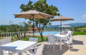 a row of tables and chairs with umbrellas and a pool at Stunning Home In Arezzo With Wifi in Arezzo
