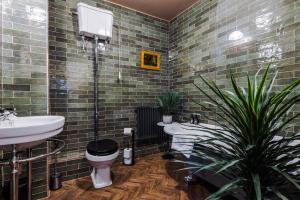 y baño con 2 lavabos, aseo y bañera. en Russell Court by Orenda-Luxe, en Llandudno