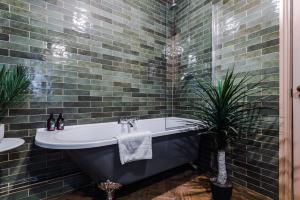 uma casa de banho com uma banheira e uma planta em Russell Court by Orenda-Luxe em Llandudno