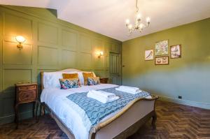 a bedroom with a large bed with green walls at Russell Court by Orenda-Luxe in Llandudno
