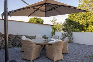 a table and chairs under an umbrella on a patio at Casa Gondiga in Roriz