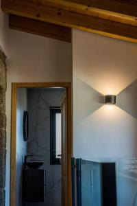 a room with a light on the wall and a bathroom at Casa Gondiga in Roriz