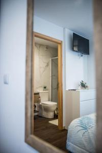 a mirror reflecting a bathroom with a toilet and a sink at Casa Gondiga in Roriz