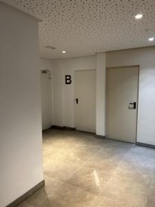 Cette chambre vide dispose de portes blanches et de carrelage. dans l'établissement Ibanova Homes Casco Antiguo 1, à Valence