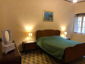 1 dormitorio con 1 cama, espejo y lámparas en Antica residenza La Rocca en Montefiascone