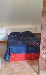 a bed with a blue comforter in a room at Tout le confort au milieu d'un parc botanique in Noyal-Muzillac