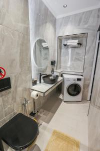 a bathroom with a sink and a washing machine at City Compass Luxury Suites in Rhodes Town