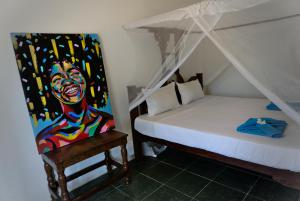 ein Schlafzimmer mit einem Bett und einem Wandgemälde in der Unterkunft Cocolala Beach House in Nungwi