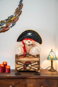 a teddy bear wearing a pirate hat sitting on a chest at Pirate Cottage Penryn Falmouth families & couples in Penryn