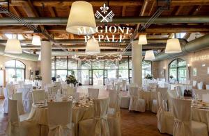 a banquet hall with white tables and chairs at Magione Papale Relais in LʼAquila