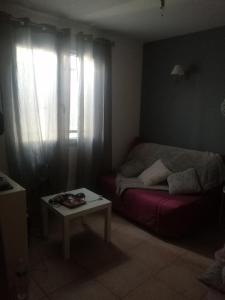 uma sala de estar com um sofá vermelho e uma janela em The happy house em Le Martinet