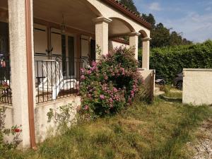 una casa con un arbusto de flores en el porche delantero en The happy house, en Le Martinet