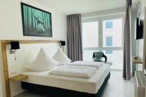ein Hotelzimmer mit 2 Betten und einem Stuhl in der Unterkunft Fewo 3-13 Ostsee in Kappeln