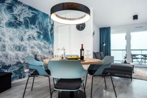 a dining room with a table and blue chairs at Fewo 3-13 Ostsee in Kappeln
