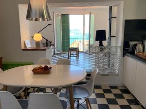 cocina y comedor con mesa y sillas en Villa Capodanna, au coeur de la vieille ville, rooftop avec magnifique vue sur la mer, en Menton