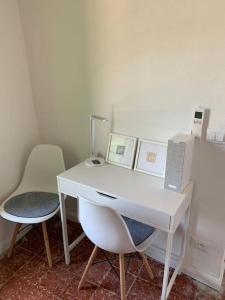 een wit bureau met een stoel en een laptop erop bij Villa Capodanna, au coeur de la vieille ville, maison de village avec magnifique vue sur la mer in Menton