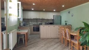 cocina con mesa de madera, mesa y sillas en Guest House Green Rose, en Borjomi
