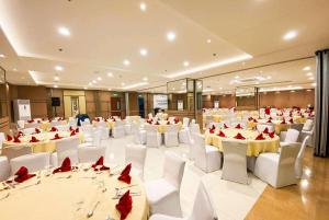 un salón de banquetes con mesas y sillas blancas y mariposas rojas en Days Hotel by Wyndham Iloilo, en Iloilo City