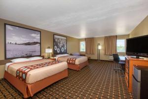 a hotel room with two beds and a flat screen tv at Super 8 by Wyndham Ottawa in Ottawa