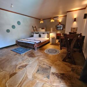 a bedroom with a bed and a desk in a room at Mambo Cabana in Pwani Mchangani