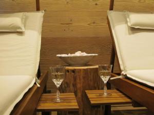 Cuore delle Dolomiti Alloggi Vacanze في سان بيترو دي كادوري: سريرين وكأسين على طاولة في الغرفة