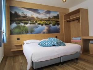 Cuore delle Dolomiti Alloggi Vacanze في سان بيترو دي كادوري: غرفة نوم مع لوحة كبيرة على الحائط