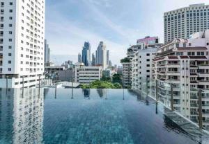 a swimming pool in a city with buildings at Modern room,Sky pool, BTS Asok,Sukhumvit in Bangkok