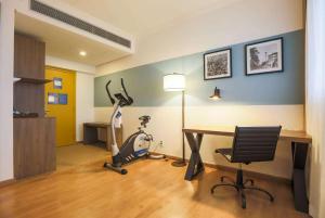 an office with a treadmill and a desk and a chair at TRYP By Wyndham Ribeirão Preto in Ribeirão Preto