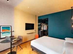 a bedroom with a bed and a desk with a laptop at Novotel Caserta Sud in Caserta