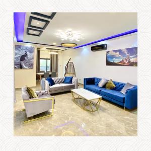 ein Wohnzimmer mit blauen Sofas und einem Tisch in der Unterkunft RESIDENCE KARMA in Ouagadougou